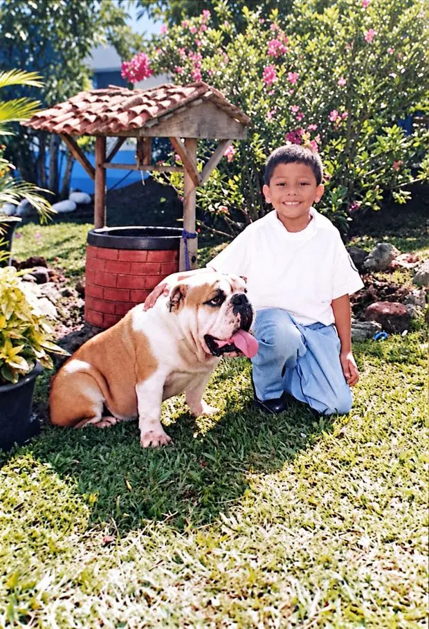 Jean de niño en un jardín junto a un Bulldog Inglés